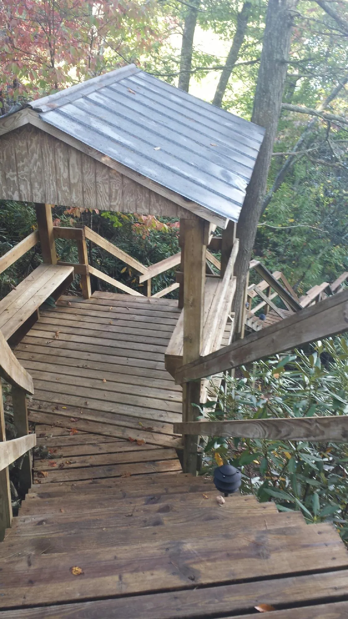 Metal roofed shelter over wooden steps on a wooded walkway — Skylight Repair & Installation work by our crew in Elizabethtown
